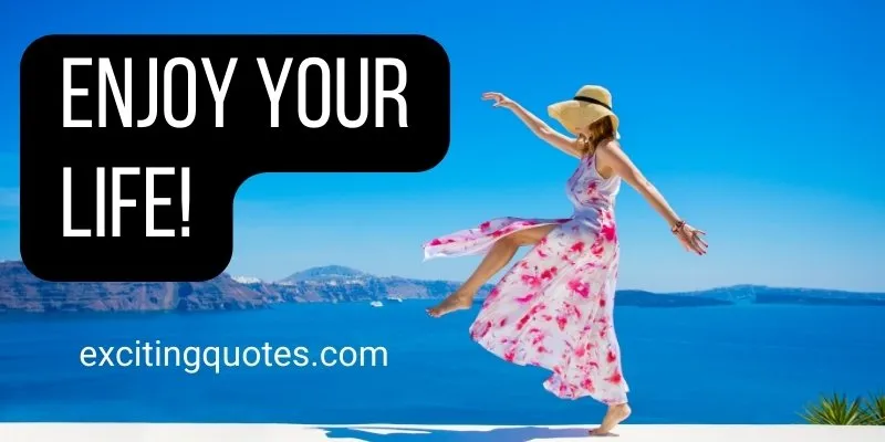 A woman in a dress and a hat stands on a ledge with the ocean with an Inspiring quote.